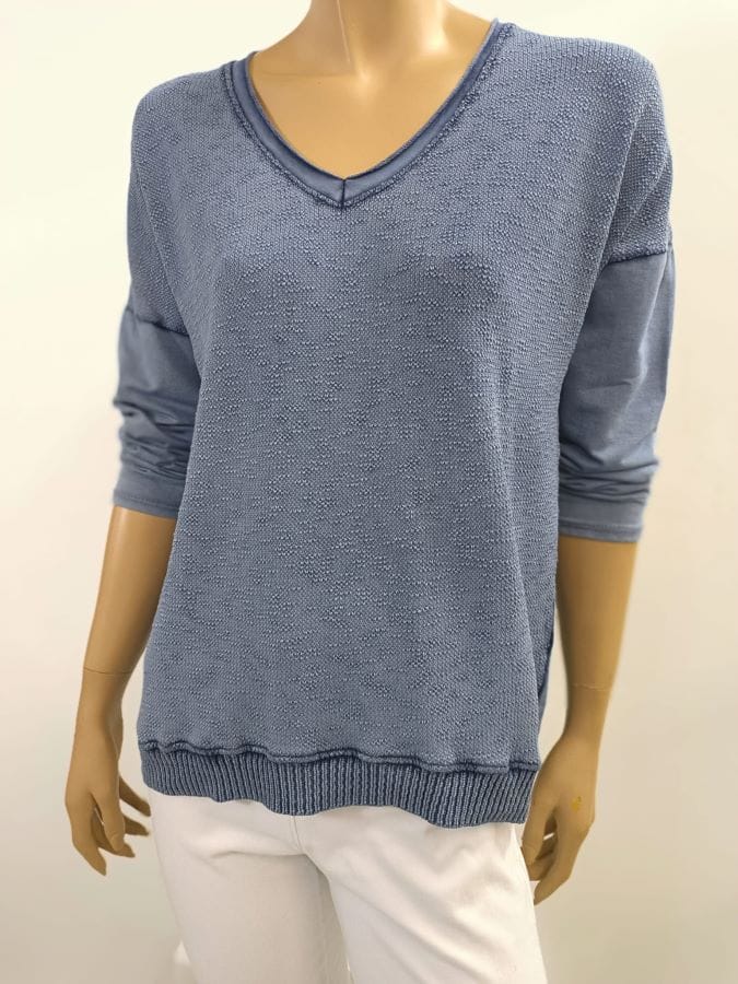 Esta camiseta azul desgastado con cuello en V es perfecta para un look casual y desenfadado. Su estilo vintage le da un toque único y especial.