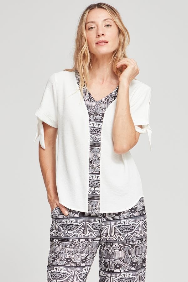 Blusa ancha de la marca Azay, en color blanco con cuello pico y detalles en negro.