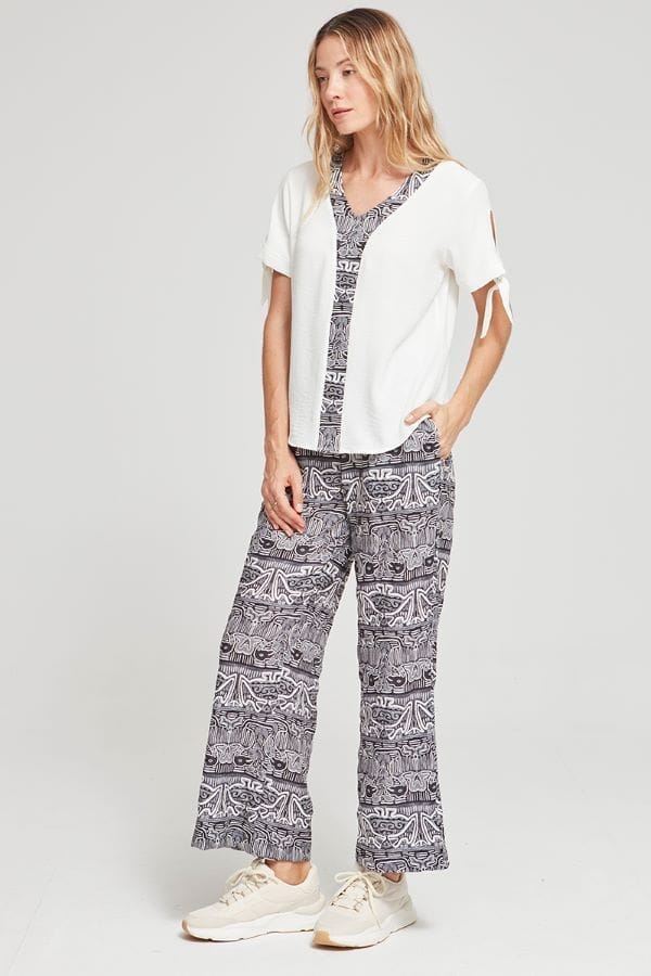 Blusa blanca de cuello pico con detalle central con tela estampada estilo africano.