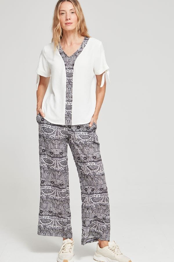 Blusa blanca cuello pico. Tiene un detalle en la zona del escote y el centro con tela blanca y negra estilo africano.