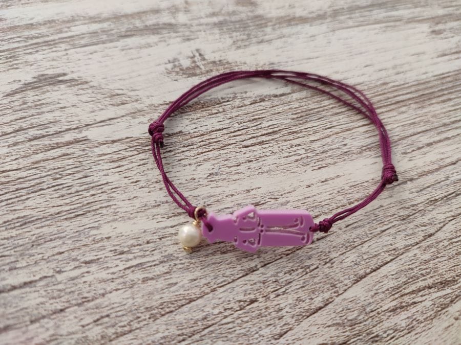 Pulsera en color rosa intenso con cordón y perla de San Roque