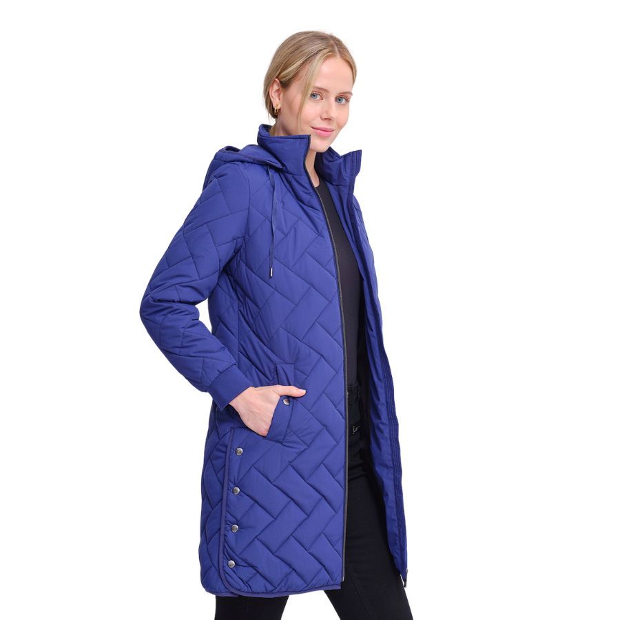 Parka Larga Azul Zafiro larga con un diseño único de acolchado en espiga. Detalle de logo circular en negro en el hombro, aportando un toque sutil de distinción.