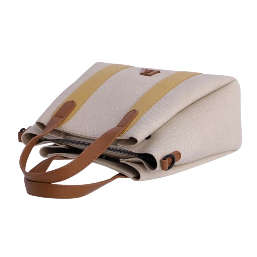Bolso Tote Mujer Chic. Perspectiva lateral de bolso de mano beige con detalles en color mostaza y herrajes negros para correa bandolera.